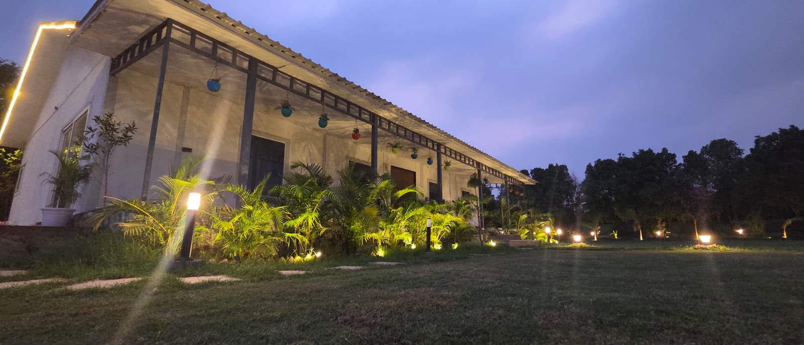 Farmhouse at dusk with garden lights